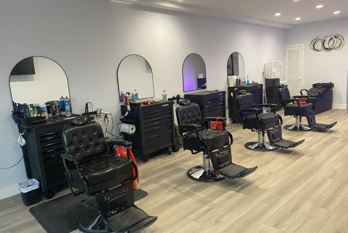 Stylish salon workspace with comfortable black chairs, mirrors, and organized styling tools for salon rental.