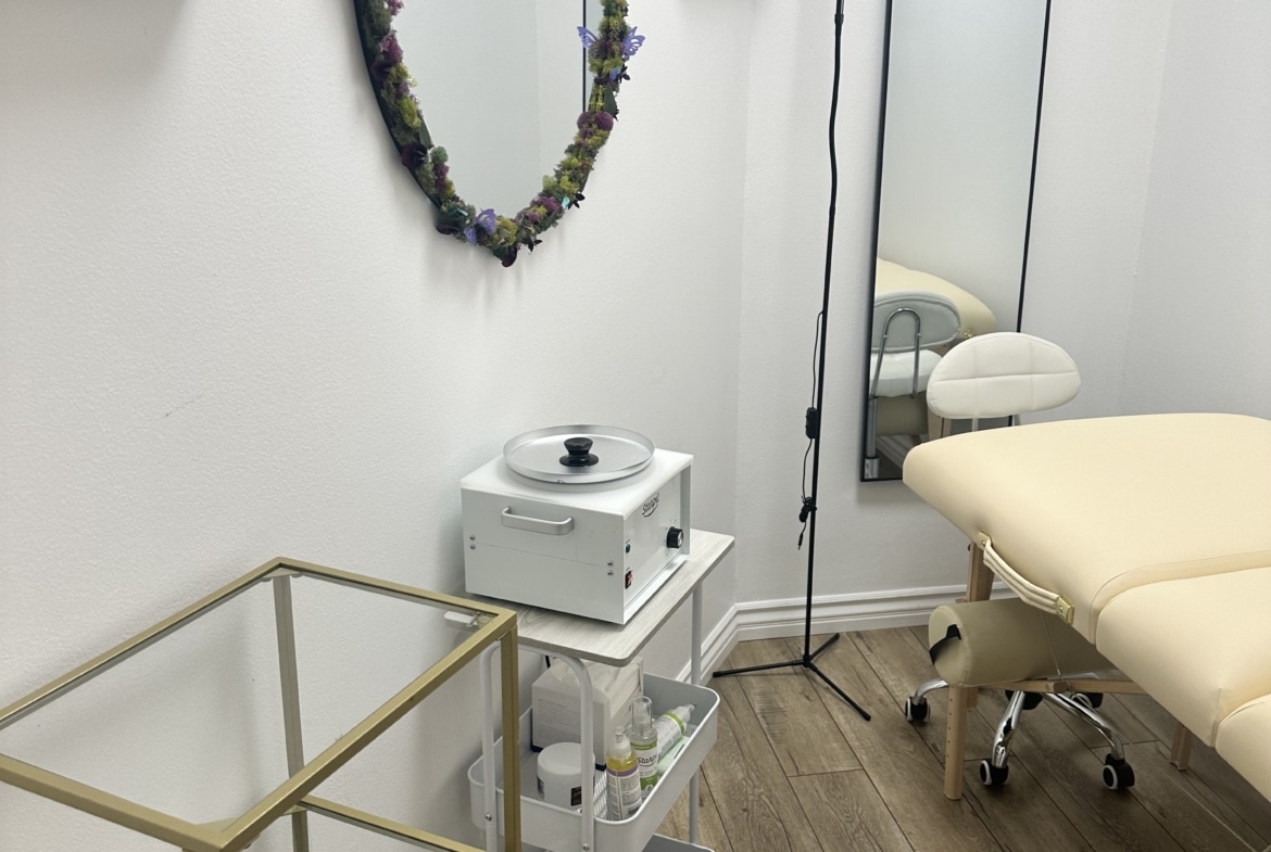 Salon room featuring massage bed and essential salon equipment for client treatments.