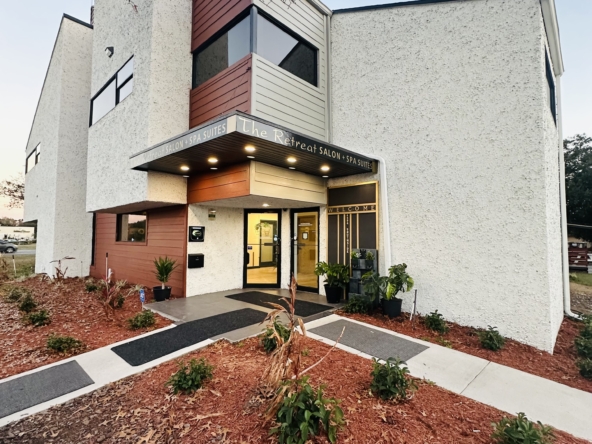 Exterior view of a contemporary salon and spa suites building with attractive landscaping and signage.
