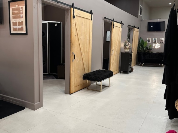 Stylish salon rental with private booths, rustic barn doors, and cozy waiting area.