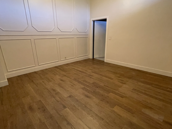 Spacious interior with stylish wall panels, wood floors, and modern lighting perfect for a salon.