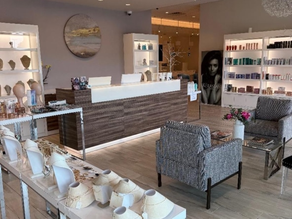 Modern salon with retail displays and stylish seating areas.