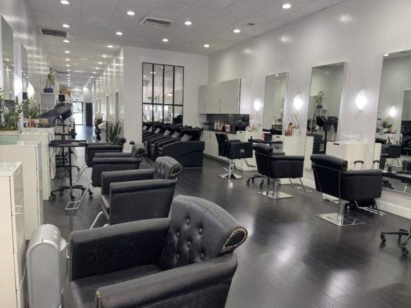 Modern salon chair stations with mirrors and styling tools for beauty professionals.