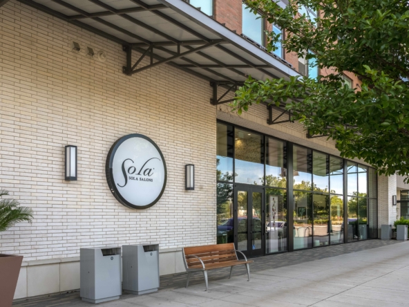 Modern salon storefront exterior with glass windows, signage, benches, and greenery for salon renter SEO.