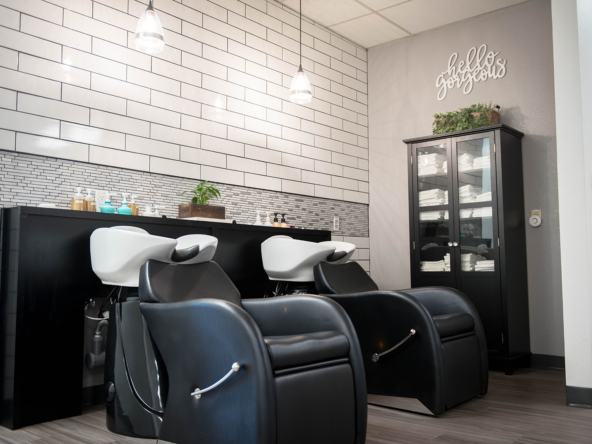 Clean salon hair washing stations with stylish black and white chairs and modern decor.