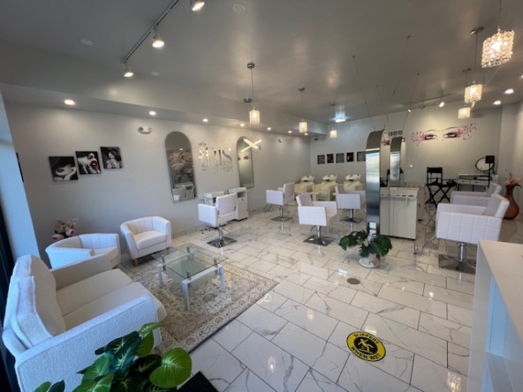Bright modern salon interior with white furniture and stylish decor for hair and beauty services.