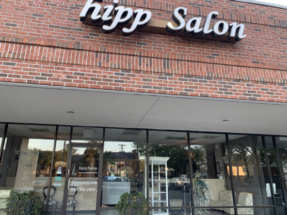 Chic salon storefront with large glass windows and stylish signage, ideal for hair and beauty services.