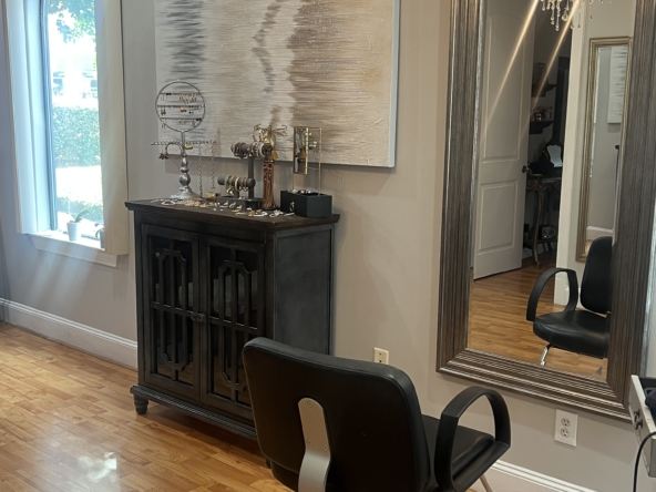 Stylish salon interior with a beauty station, large wall mirror, and elegant decor for hair and beauty services.