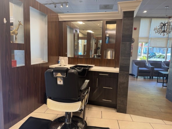Modern salon styling station with mirror, chair, and wood accents, perfect for hair and beauty services.