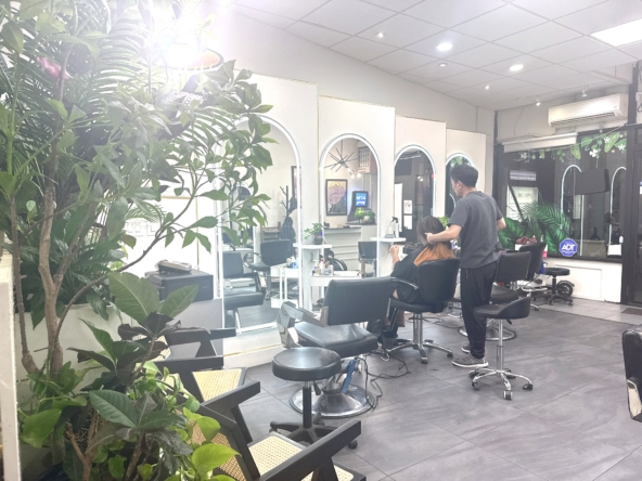Bright salon interior with hair styling stations, stylish mirrors, and greenery for a modern salon experience.