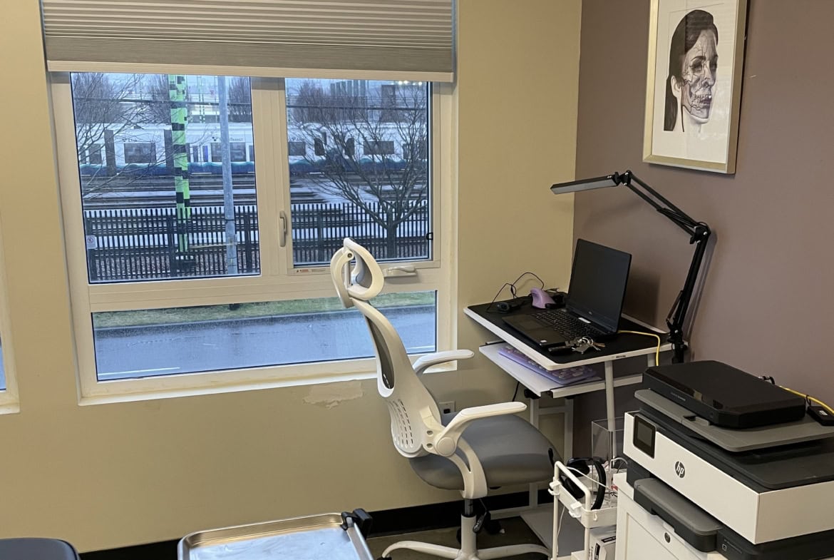 Office workspace with a desk, computer, and printer in a salon environment.