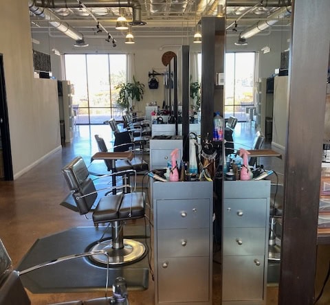 Modern salon with multiple styling stations, large windows, and contemporary decor for a professiona.
