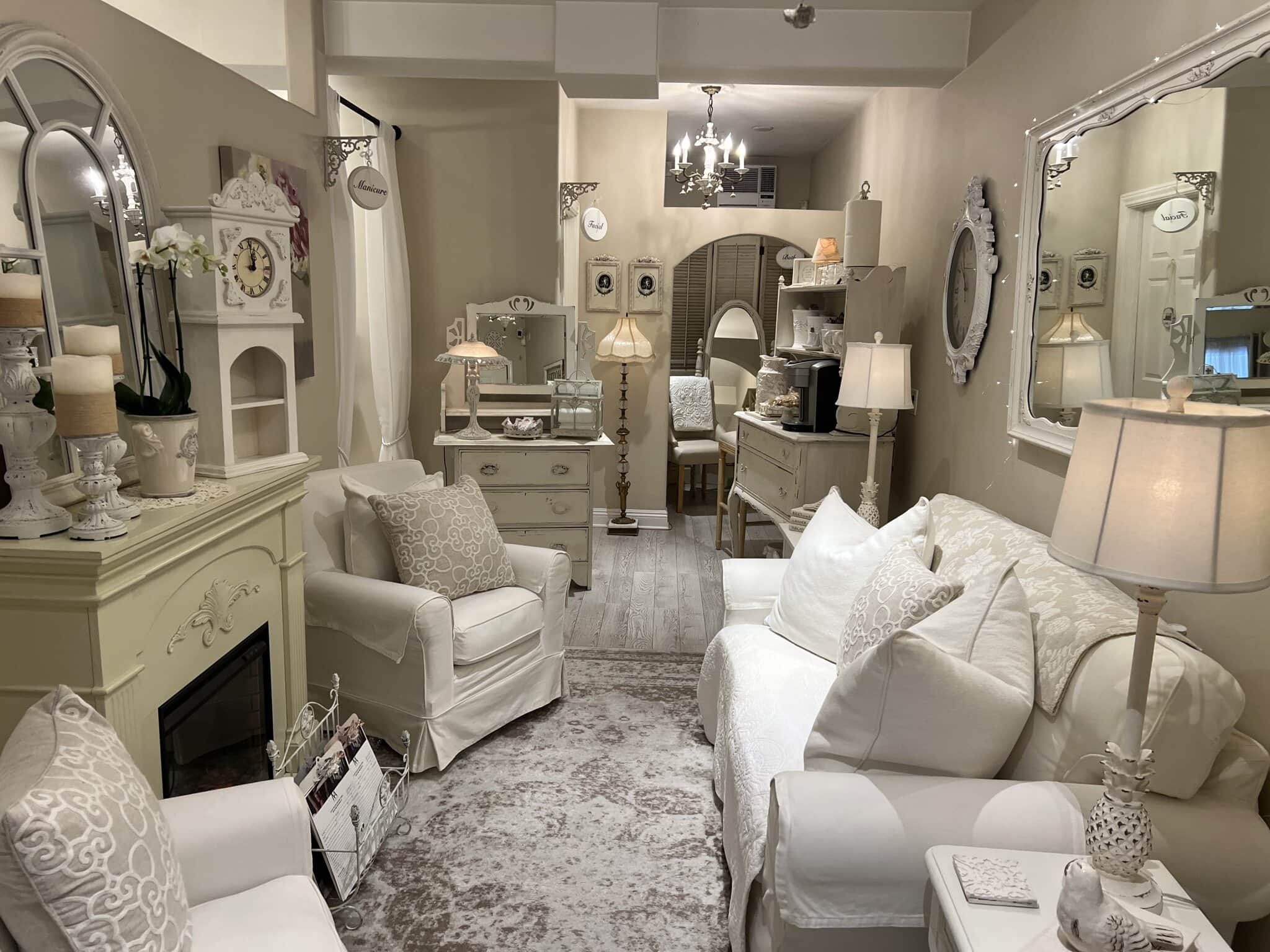 Cozy salon lounge featuring white sofas, vintage mirrors, and elegant decor, perfect for relaxing or.
