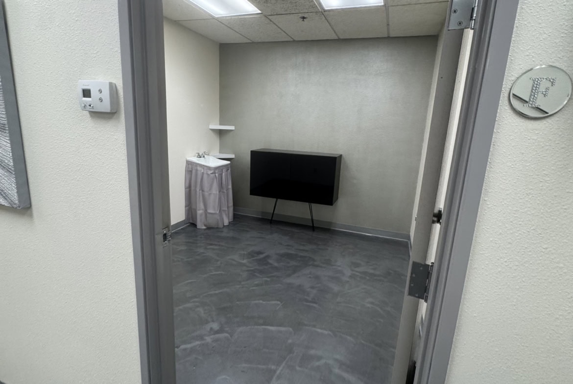 Small private room for salon renters with minimal decor and basic amenities.