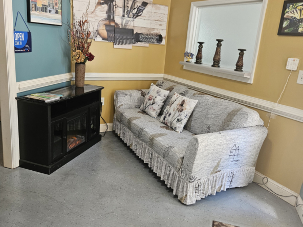 Comfortable sofa in salon waiting area with decorative pillows and artwork.
