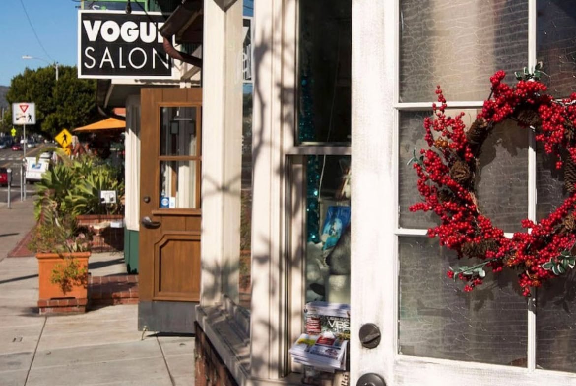 Outdoor view of Salon Renter with festive wreath on door and sidewalk scene.