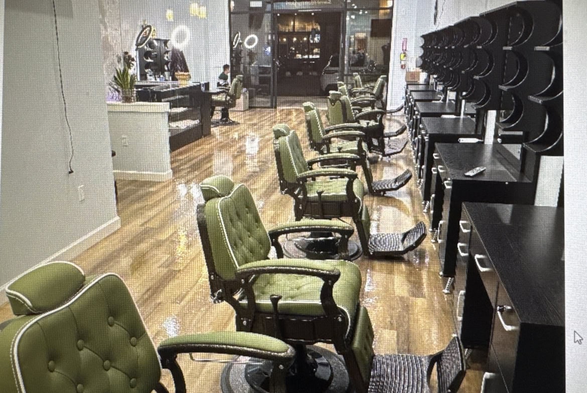 Stylish hair salon with green chairs and modern styling stations for clients and stylists.
