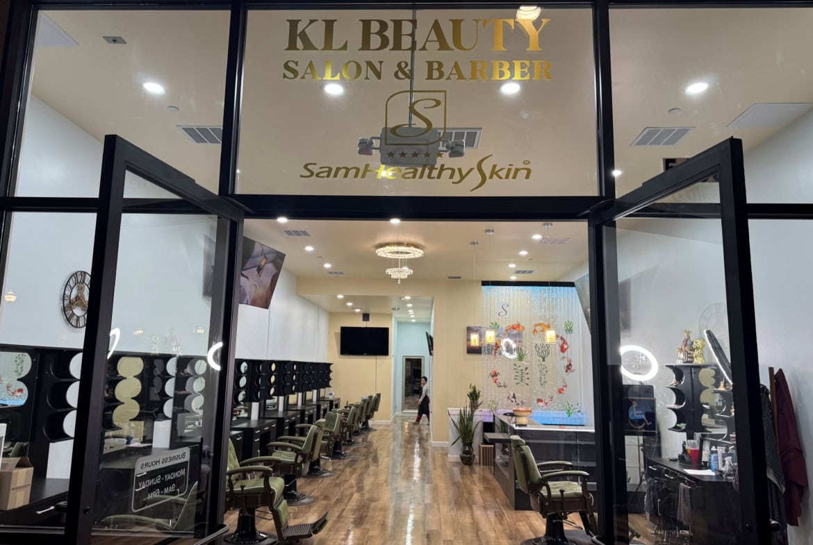Modern salon interior with styling stations and barber chairs.