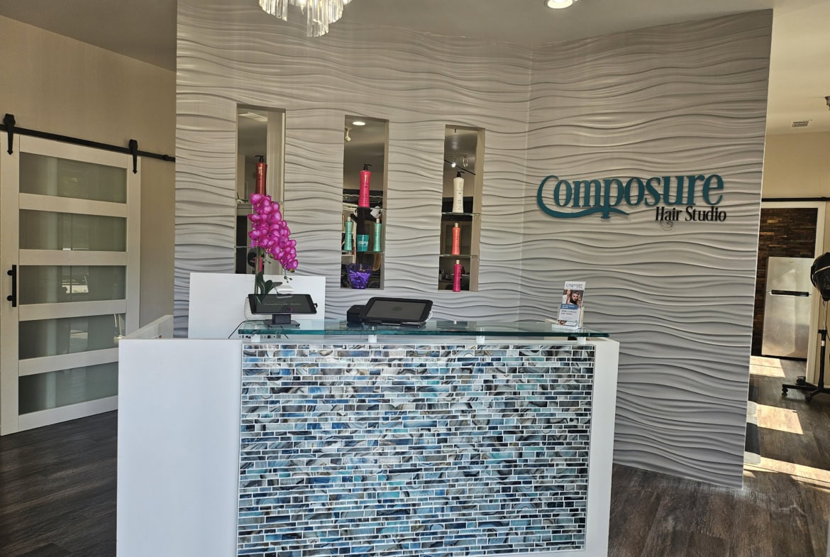 Reception desk at Composure Hair Studio with modern decor and colorful accents.