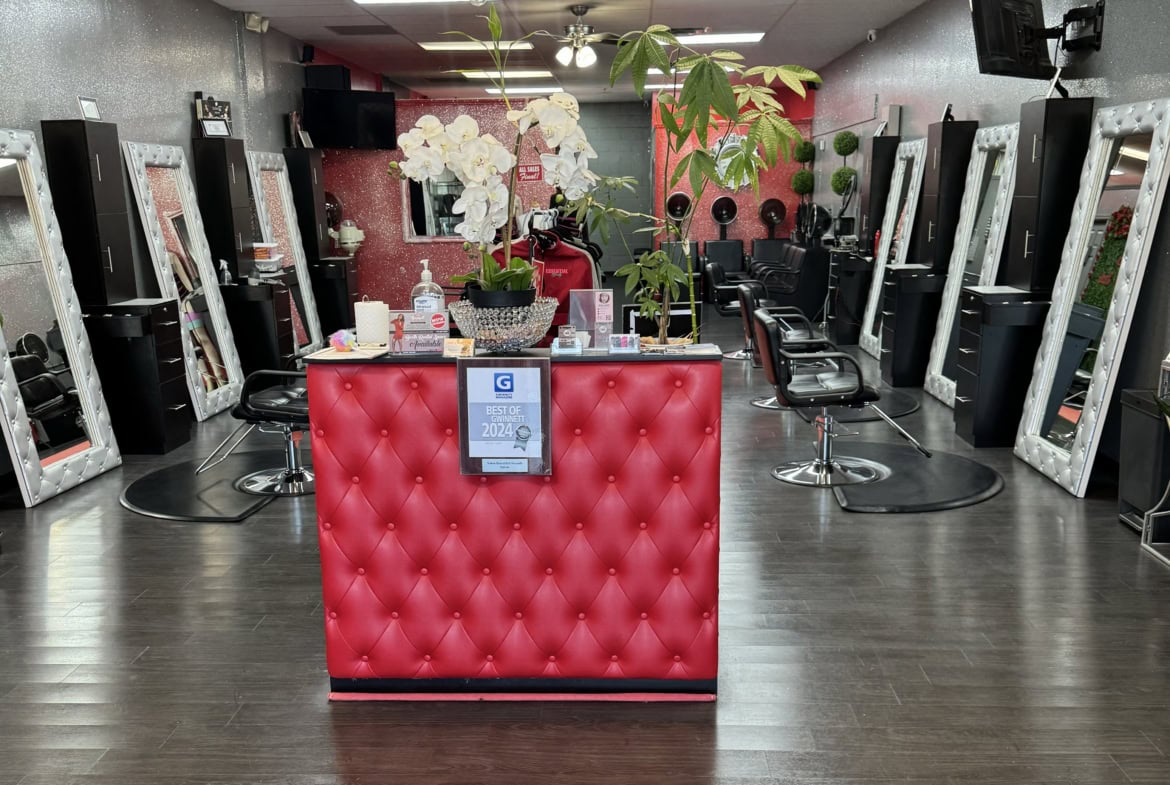Hair salon reception with styling stations and mirrors.