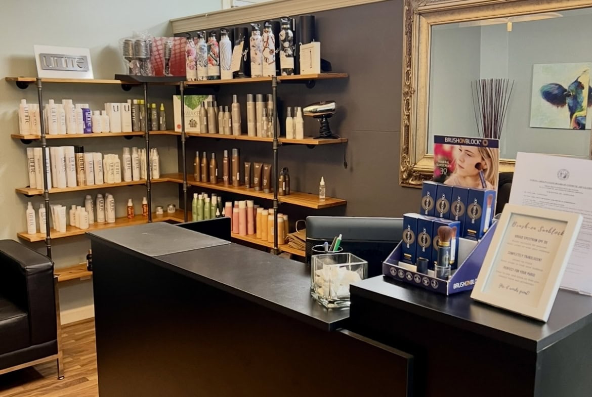 Stylish salon reception with books, mirror, and modern decor.