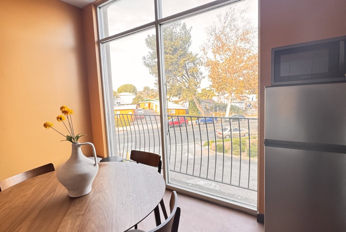 Modern salon break room with large window and wooden table Modern salon break room with large window and wooden table for staff relaxation.