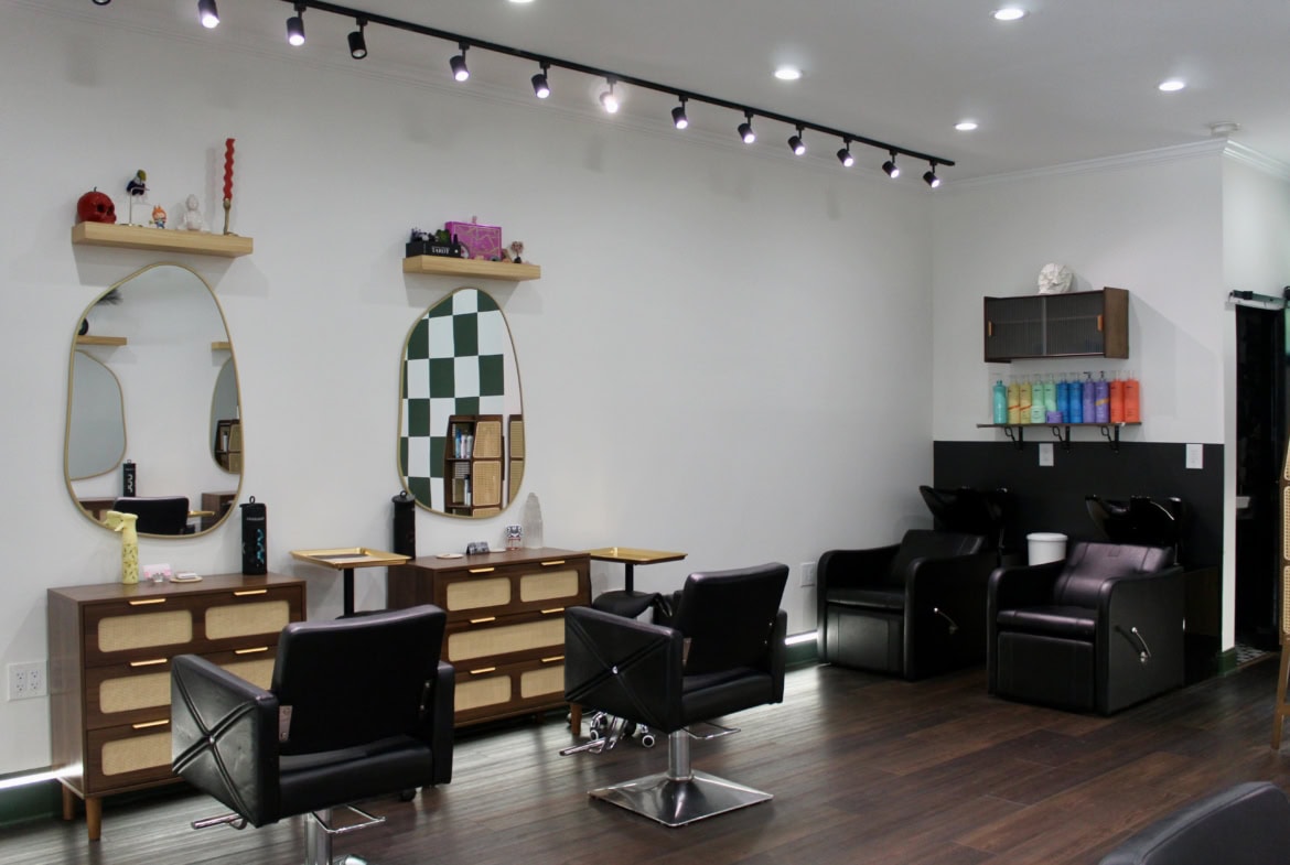 Stylish salon interior with mirrors, chairs, and hair washing stations for professional hair service.