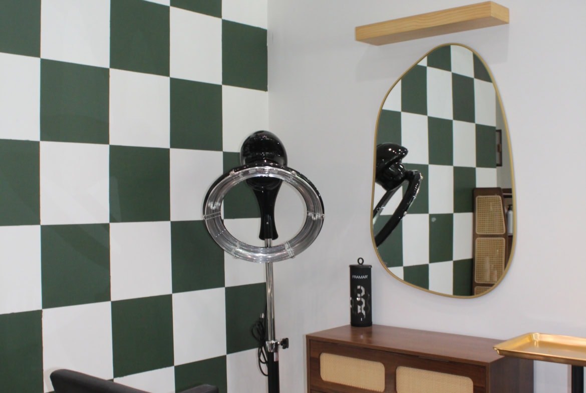 Modern salon interior with checkered wall design and styling station.