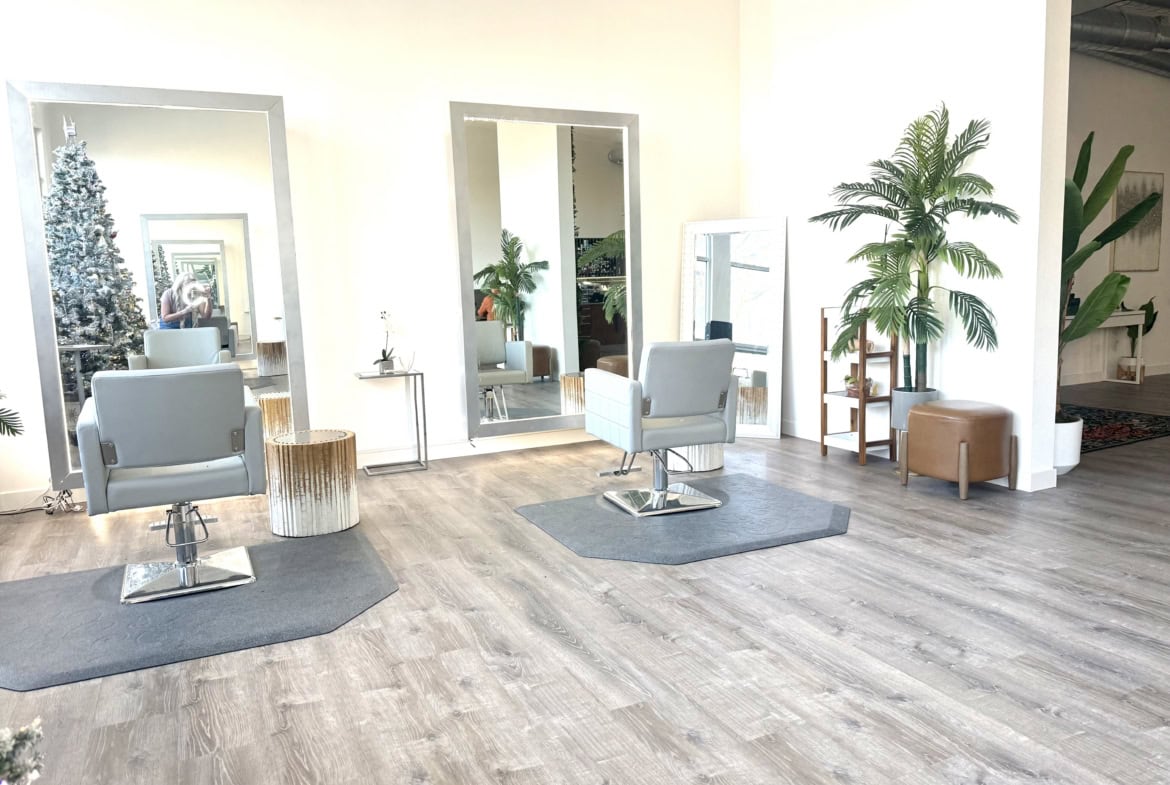 Bright salon with stylish chairs, mirrors, and lush plants for a welcoming hair salon environment.