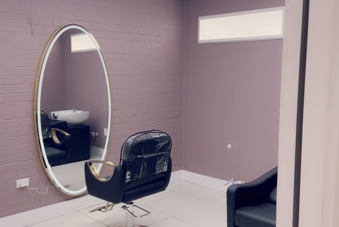 Salon Renter styling station with mirror and chair.