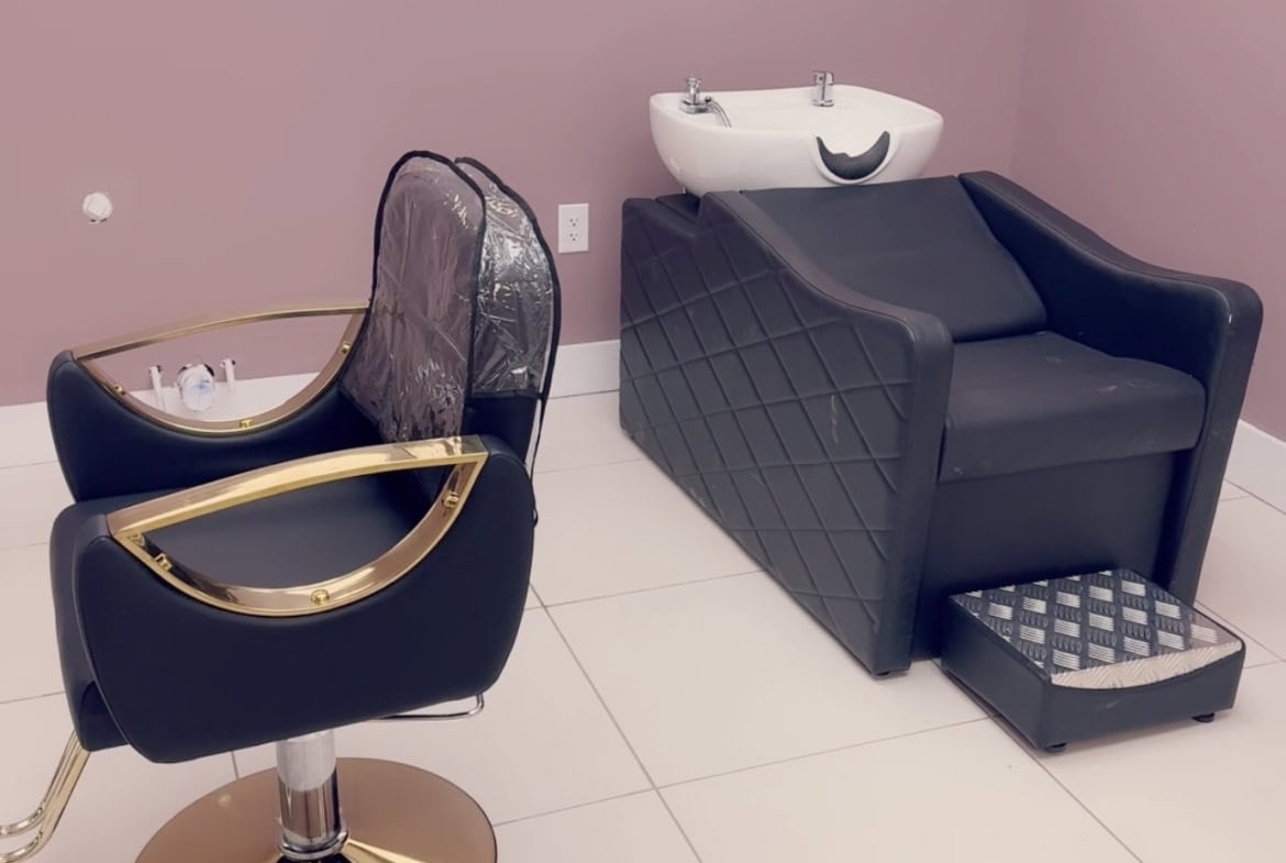 Modern salon hair washing station with comfortable chair and sink setup.