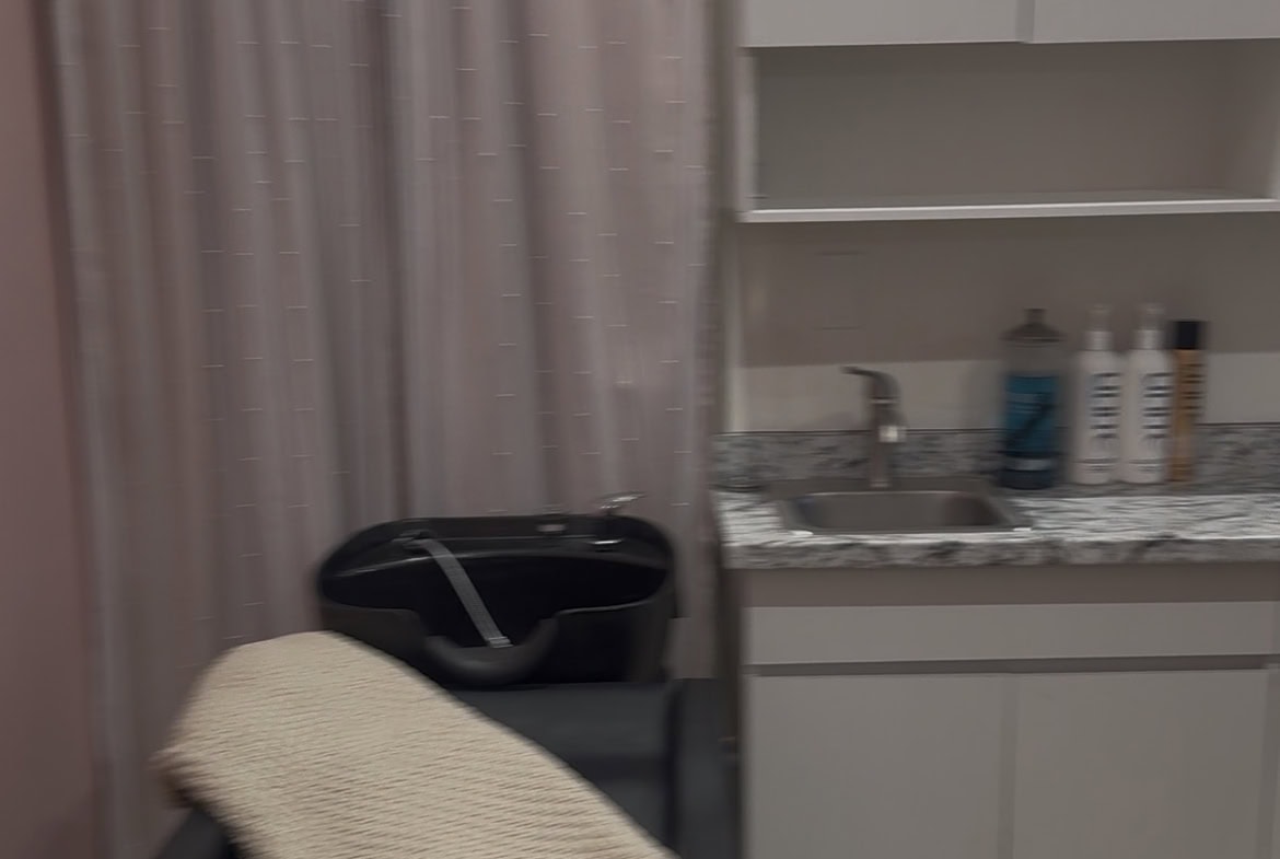 Exam room with chair, blanket, and medical supplies.