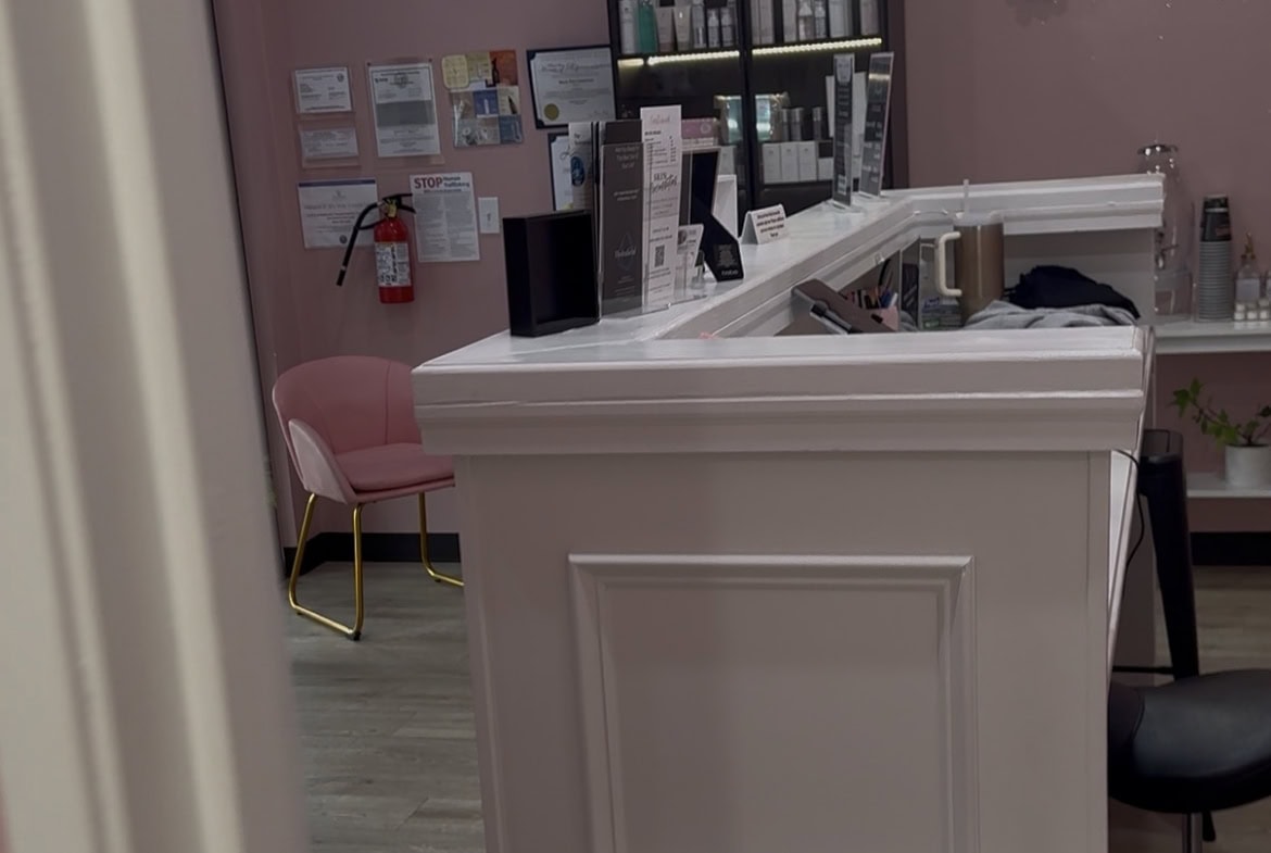 Reception desk at Salon Renter with beauty products and decor.