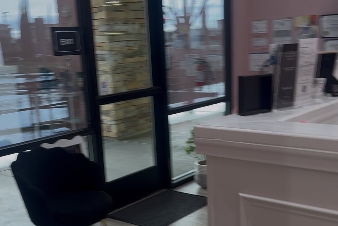 Salon Renter entrance featuring glass doors and a cozy waiting space for clients.