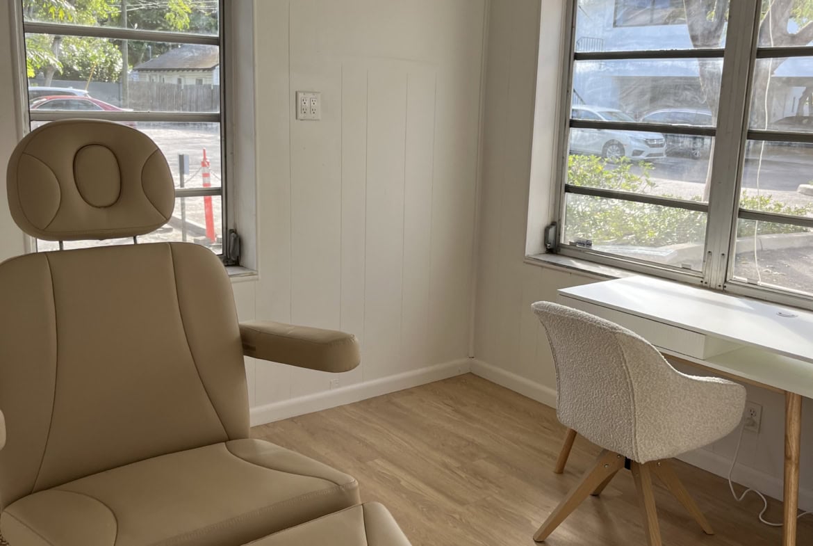 Cozy salon office with chair and desk near windows, ideal for beauty professionals.
