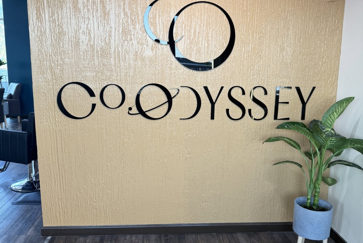 Odyssey Salon Renter Reception Area Modern salon reception with Odyssey logo and potted plant.