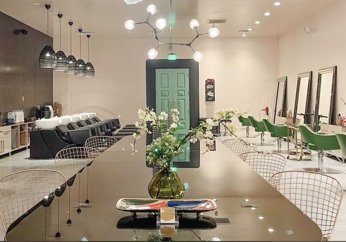 Modern salon interior with styling stations, mirrors, and comfortable seating for clients.