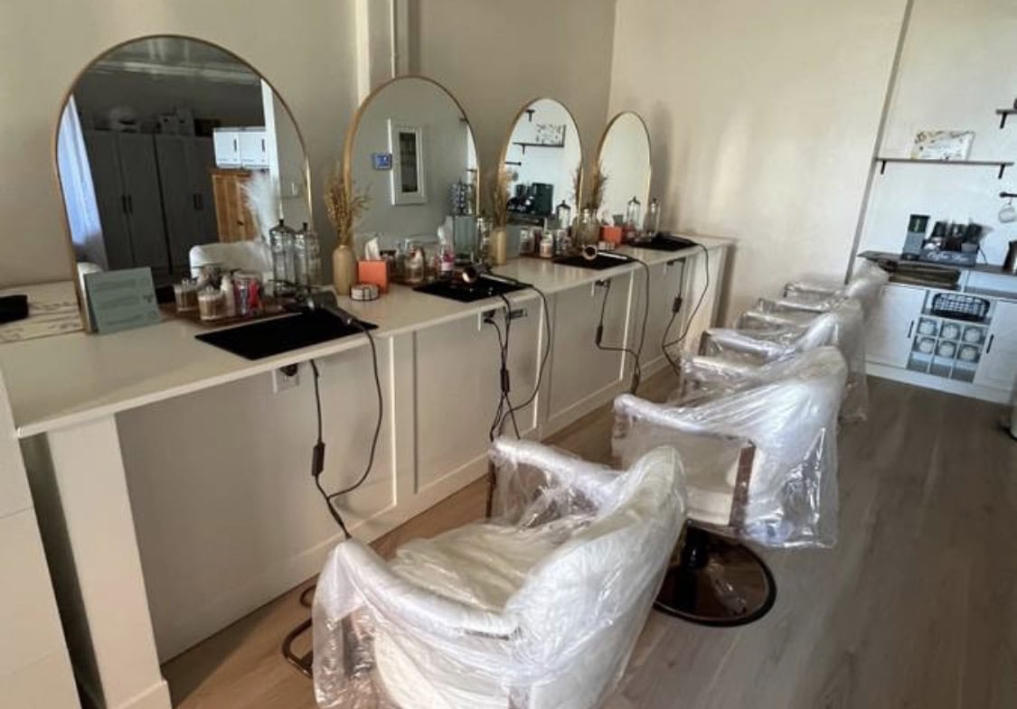 Styling station with mirrors, chairs, and salon tools for hairdressing services.