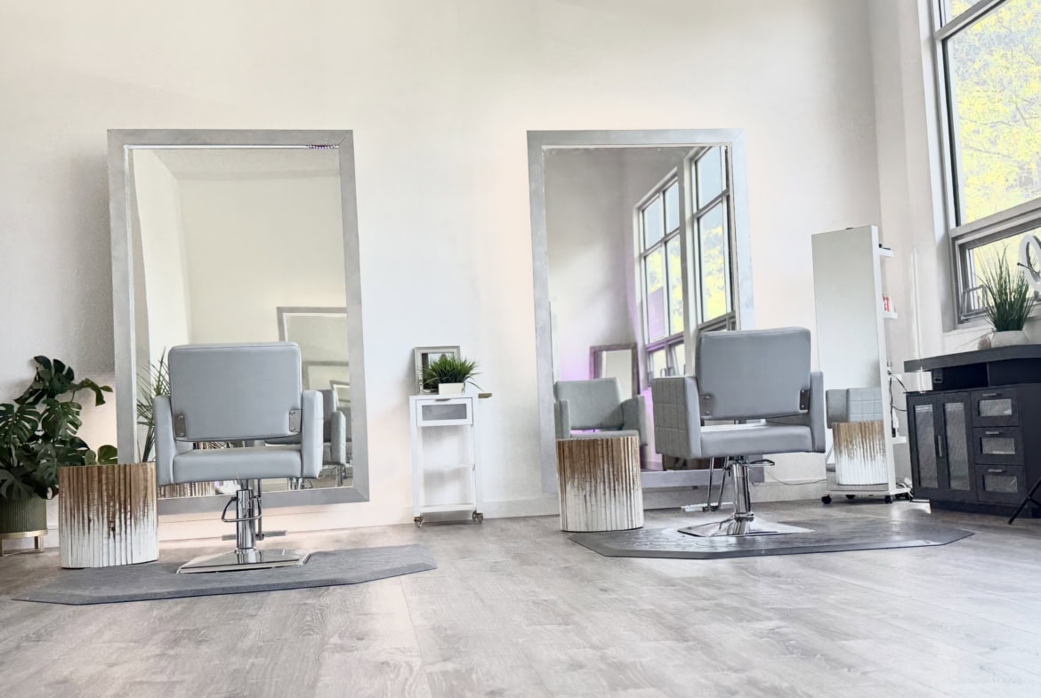 Stylish salon with comfortable chairs, large mirrors, and natural light for a professional hairdress.