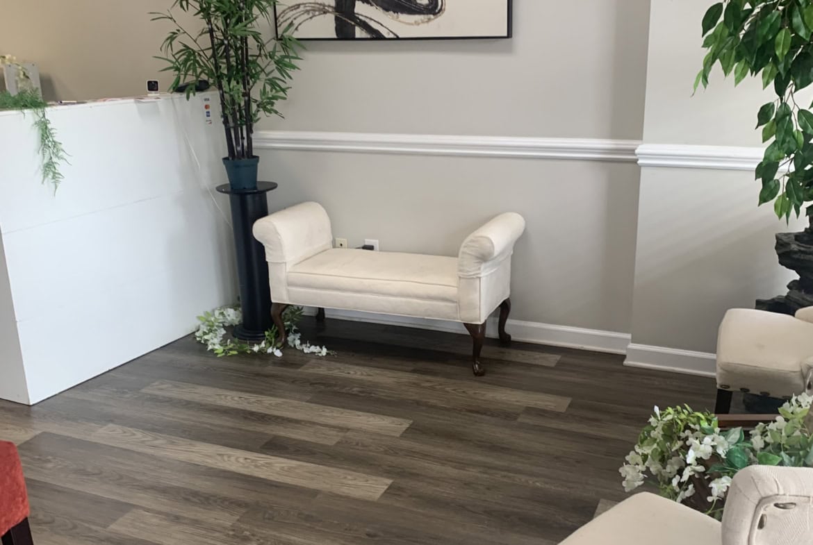 Modern salon waiting area with stylish chairs, artwork, and greenery.