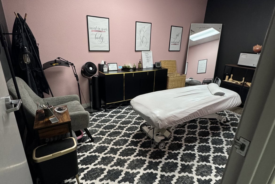 Cozy salon treatment room with massage table, stylish decor, and relaxing ambiance.