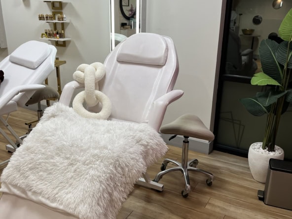 Relaxing spa treatment chair with plush blanket and cozy decor.