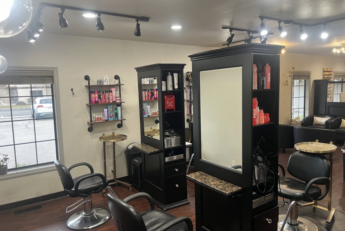 Modern salon interior with styling stations, mirrors, and hair products.