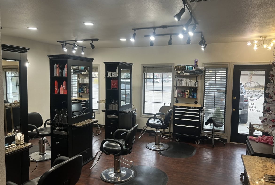 Salon Renter hair salon interior with styling stations, chairs, and shelves for hair products.