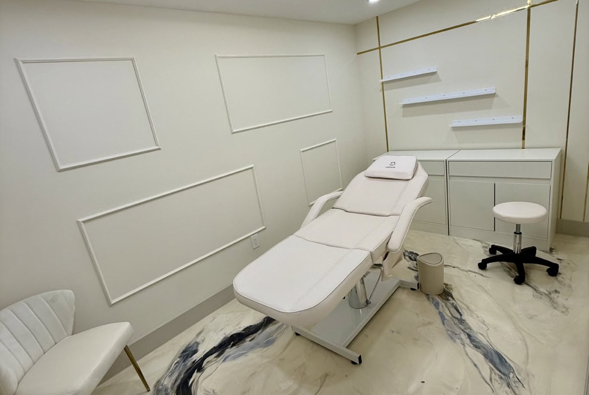 Relaxing salon treatment room with white walls, modern decor, and comfortable treatment bed for clie.
