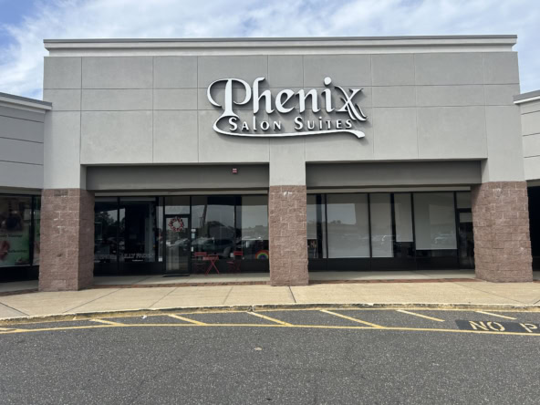 Modern Phenix Salon Suites storefront with large glass windows and signage.