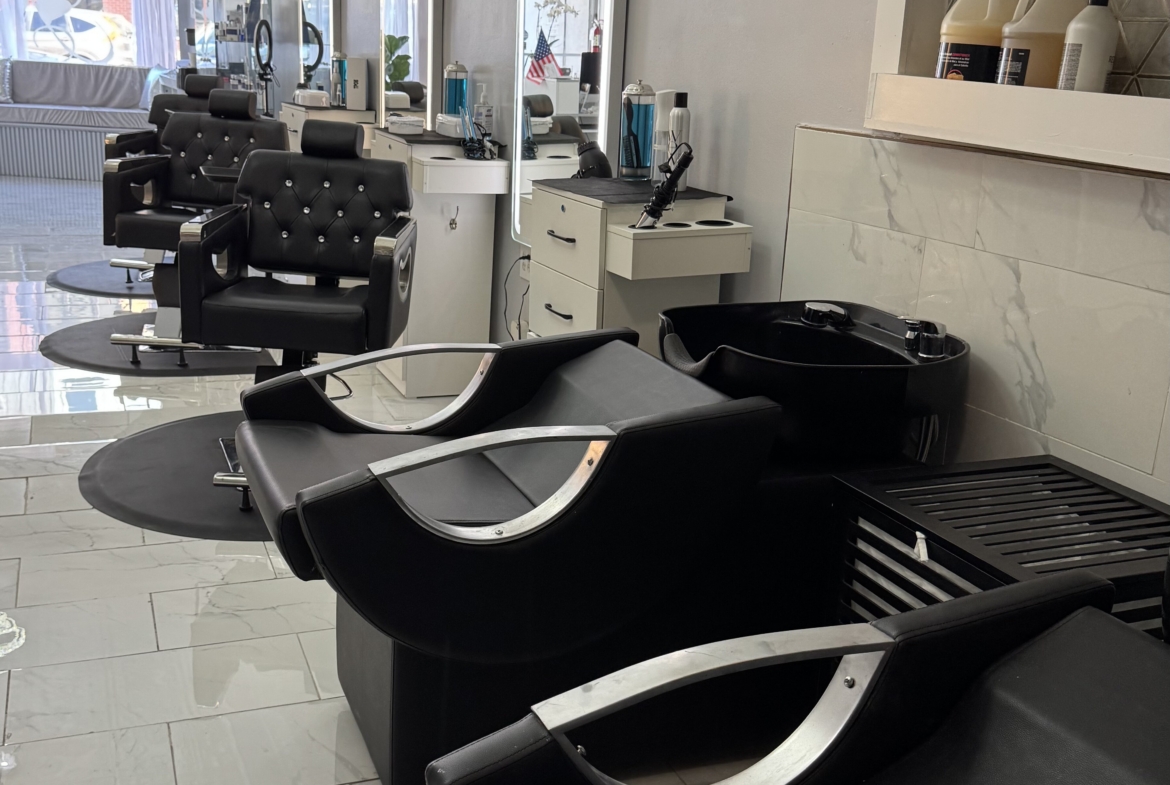 Salon interior with hair washing stations and styling chairs for haircuts and treatments.