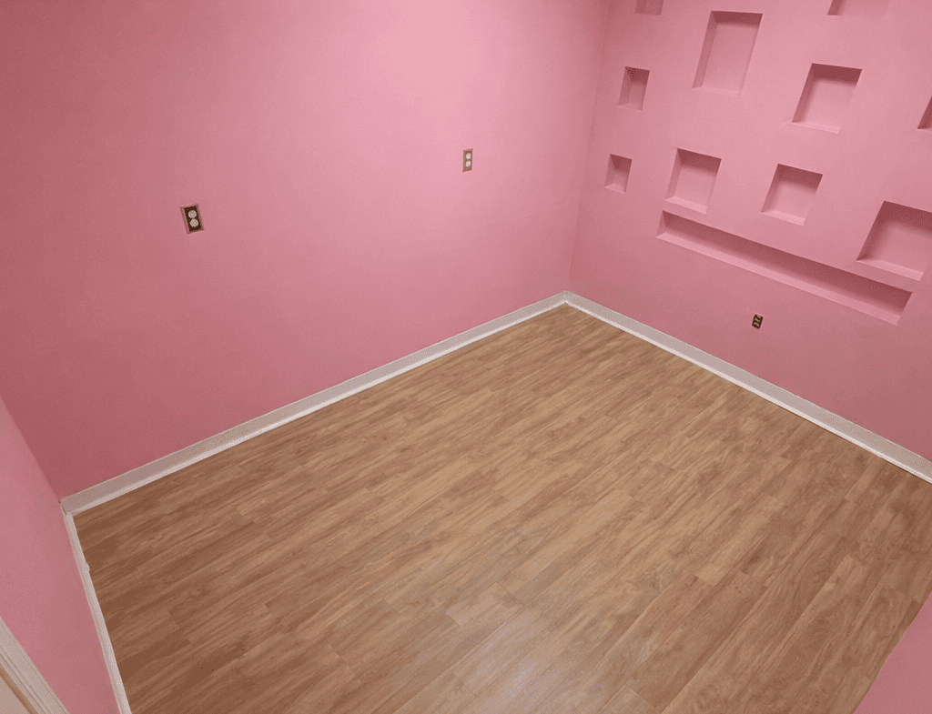 Bright pink salon space with wall niches, hardwood floor, ideal for beauty or hair styling.