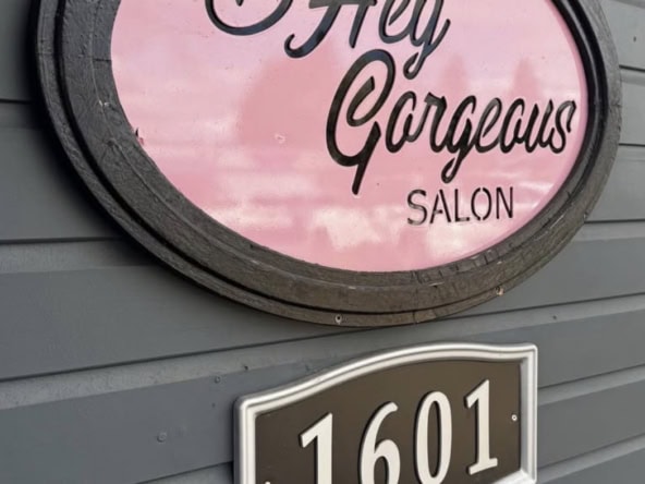 Hey Gorgeous Salon sign on gray exterior wall with address 1601.